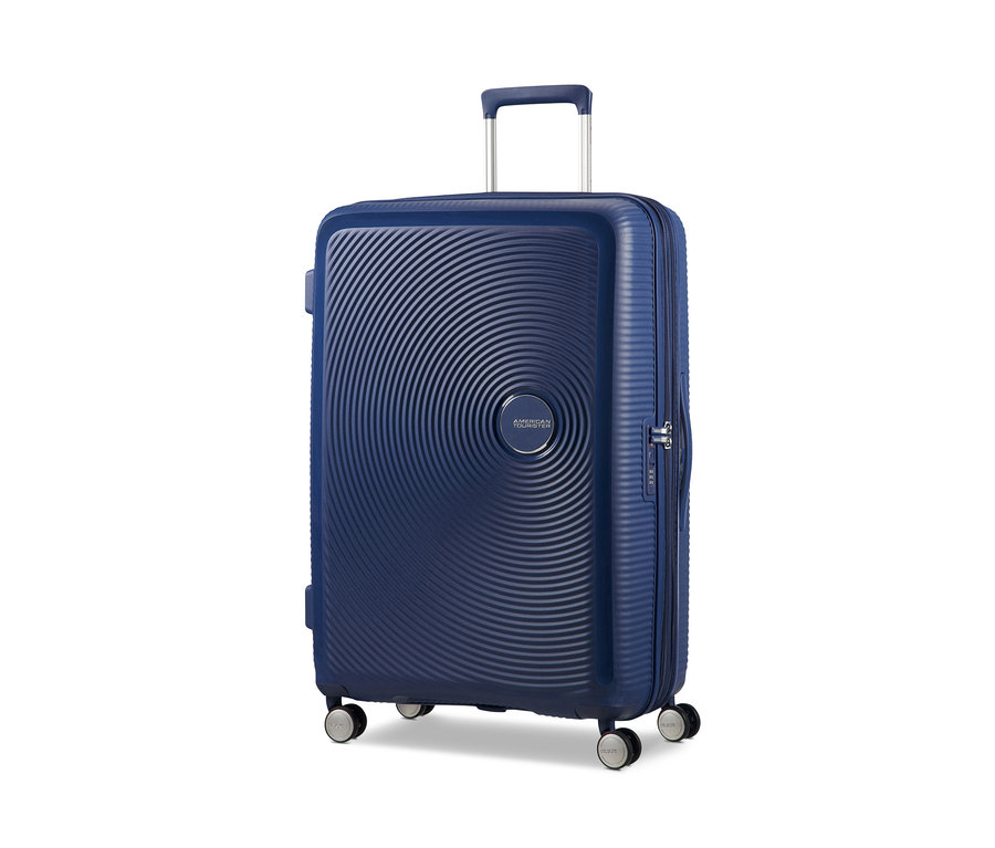 Ein großer, marineblauer American Tourister Hartschalen-Koffer »Soundbox« Spinner steht vor einem weißen Hintergrund.