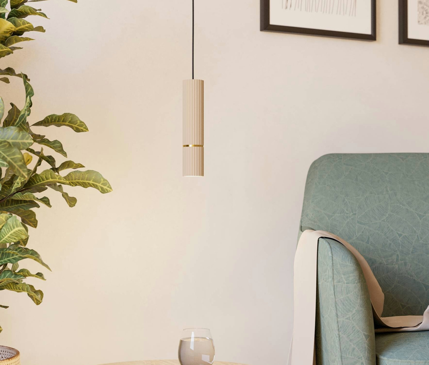 Eine Hängelampe über einem Tisch mit einem Buch und einem Glas, neben einer grünen Pflanze und einem Sessel.