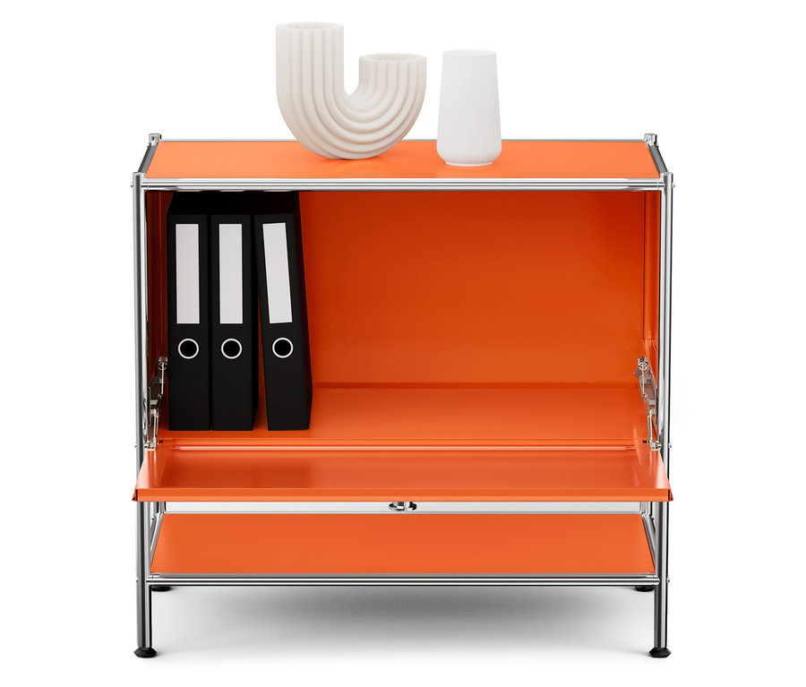 Ein orangefarbener Schrank mit verchromtem Rahmen. Darin befinden sich drei schwarze Ordner und zwei weiße dekorative Vasen.