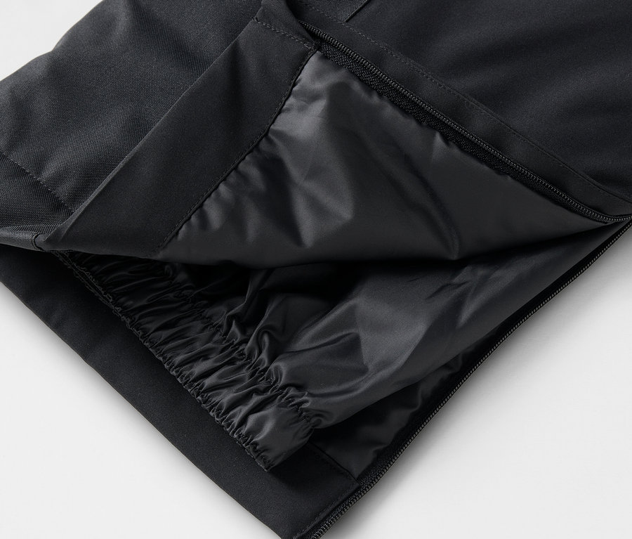 Detail einer schwarzen Hose mit geöffnetem Reißverschluss und Innenschicht.