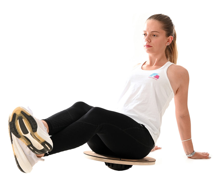 Frau sitzt auf einer F2 Round Balance Plate.