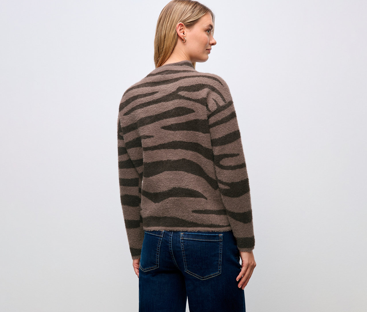 Eine Frau trägt einen Street One Jacquard-Pullover und Jeans, von hinten gesehen.