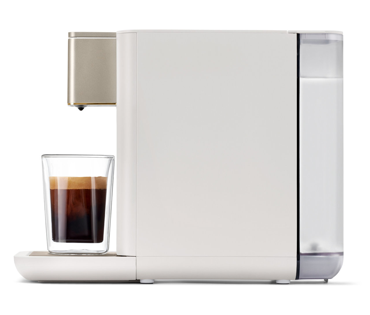 Qbo ICONIC Light Gold Kaffeemaschine bereitet Kaffee in einem Glas zu.