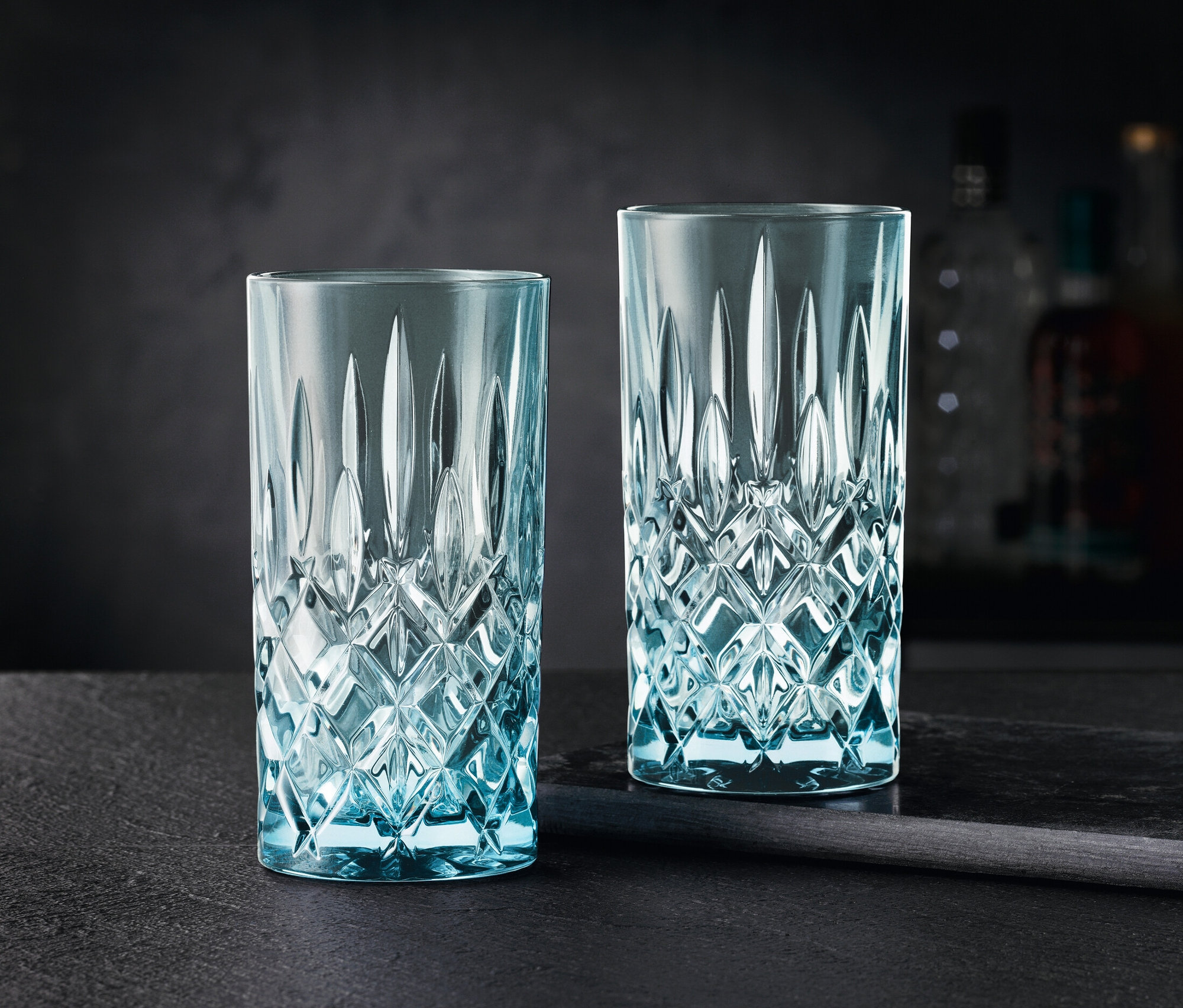 Zwei aqua Nachtmann Noblesse Colors Longdrink Gläser auf einem schwarzen Tisch.