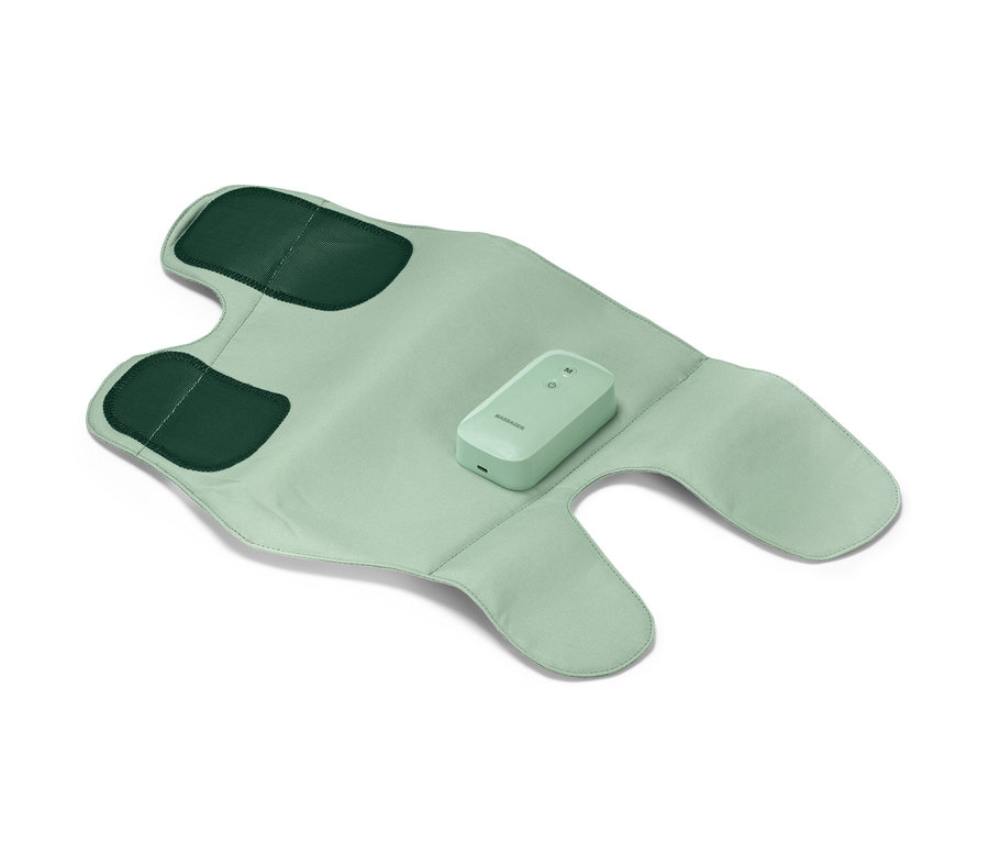 Eine hellgrüne Akku-Massage-Manschette liegt ausgebreitet, mit dunkelgrünen Applikationen und Bedienelement in der Mitte.