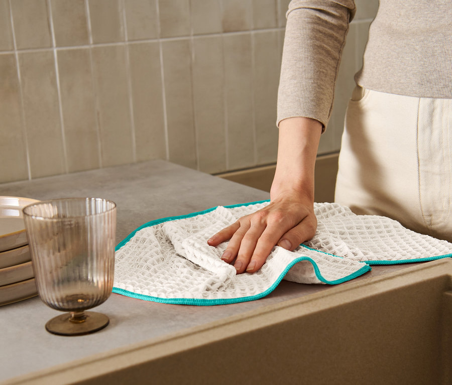 Frau wischt eine Arbeitsfläche mit einem extragroßen Trockentuch ab.