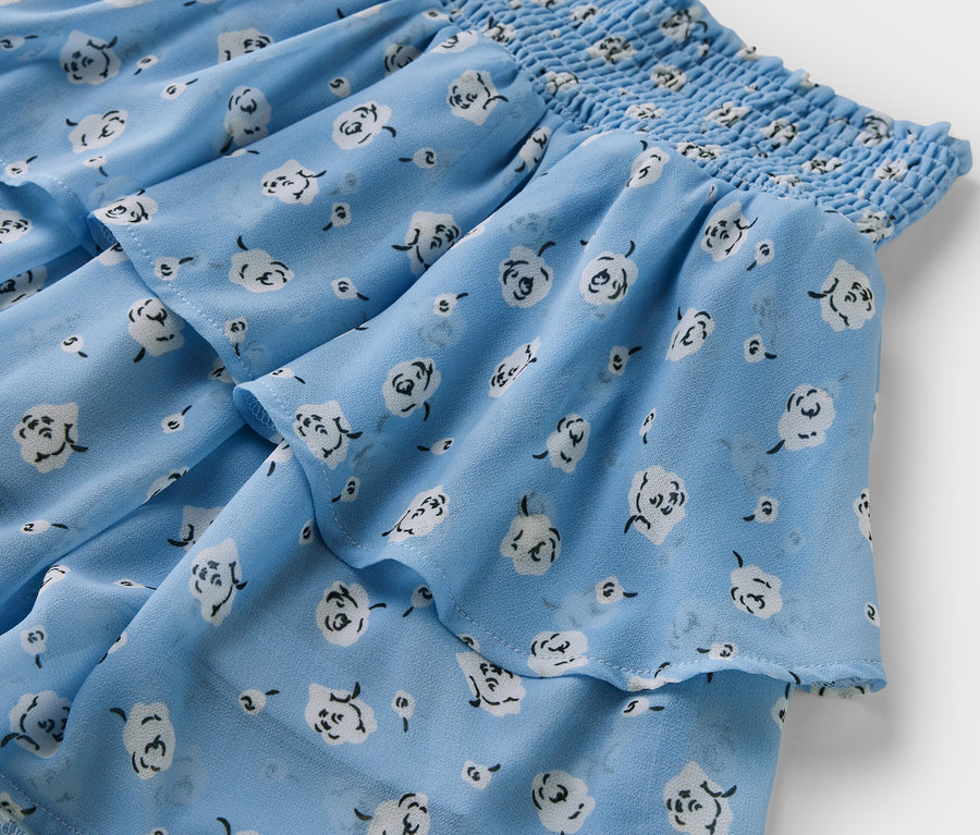 Detailansicht eines Kinder-Stufenrocks mit Blumenmuster.