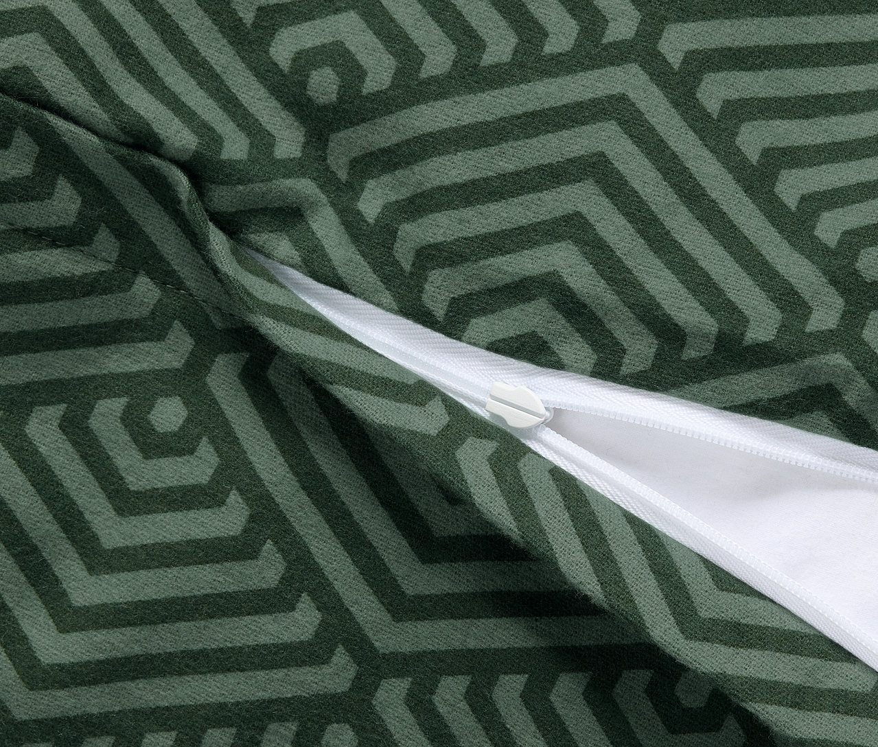 Detailansicht von zwei grünen Biber-Kopfkissenbezügen mit geometrischem Muster und Reißverschluss.