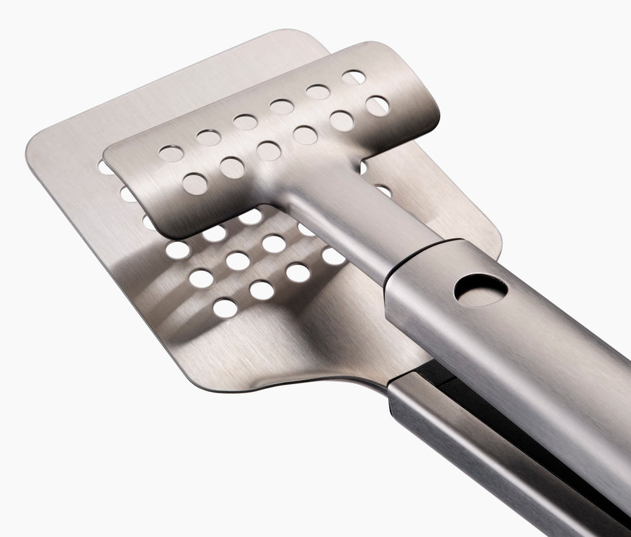 Nahaufnahme einer Burgerpresse aus Edelstahl mit Löchern.