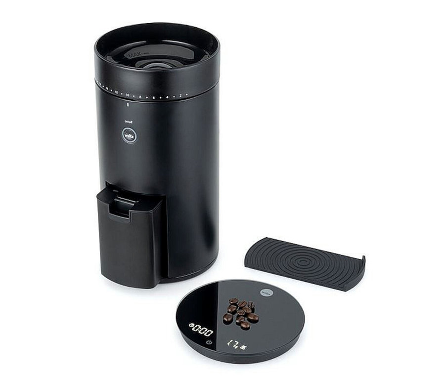 Schwarze Wilfa Kaffeemühle »Svart Uniform+« mit Kaffeebohnen auf einer schwarzen Digitalwaage.