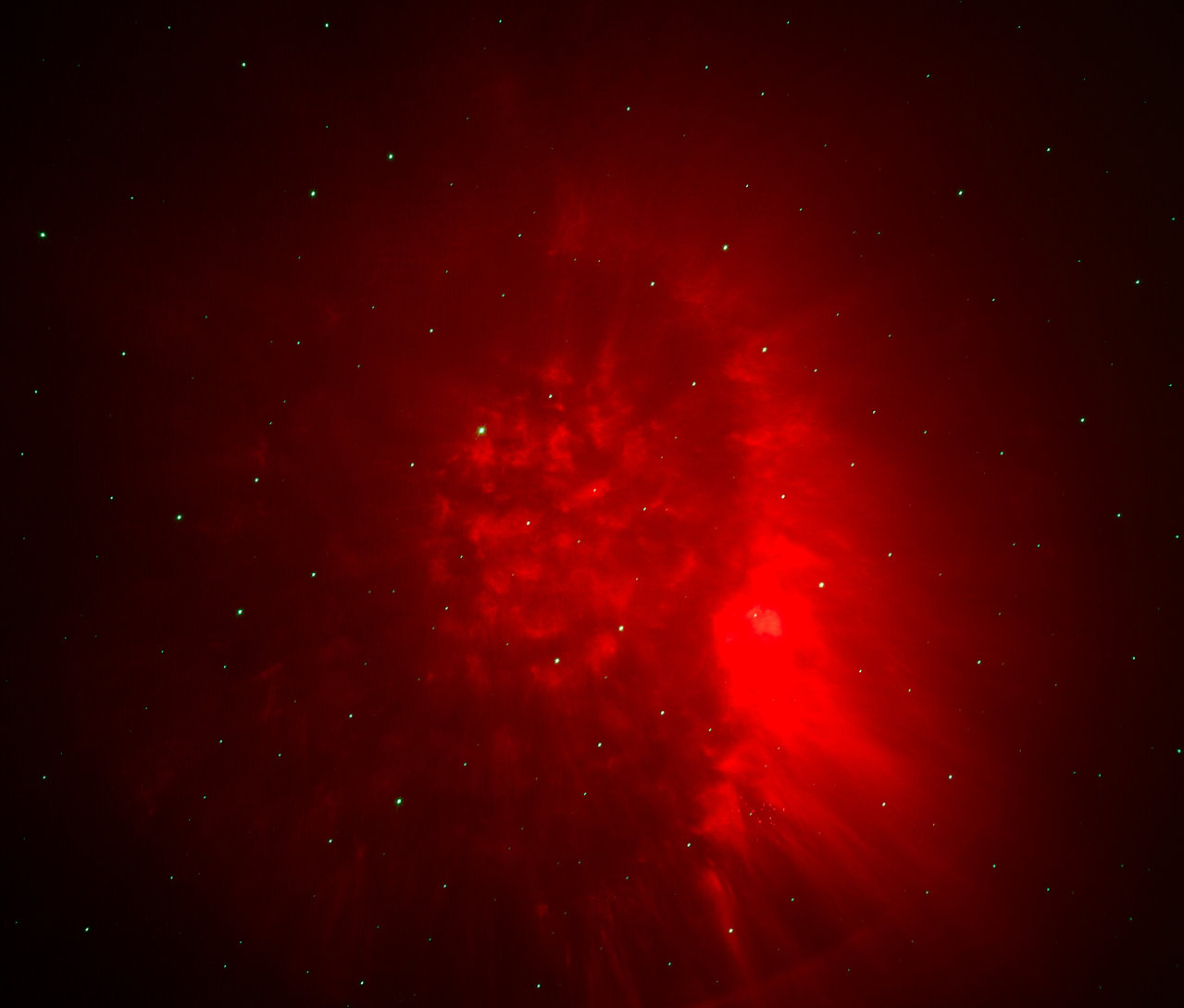 Ein roter Nebel mit Sternen auf dunklem Hintergrund.