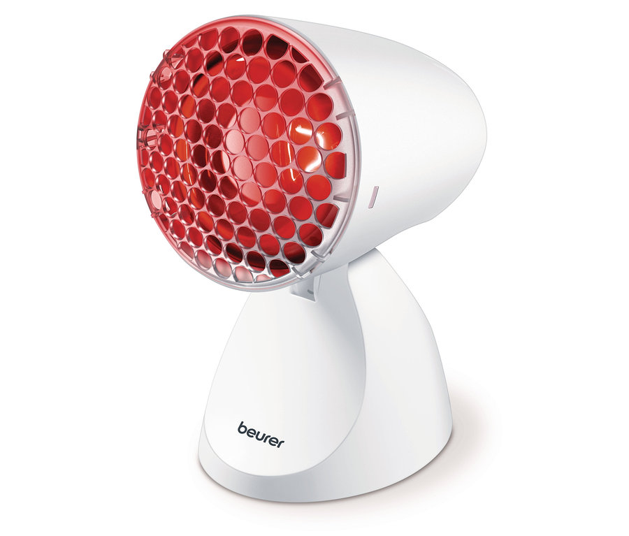 Nahaufnahme einer Beurer Infrarotlampe mit rotem Licht auf einem weißen Ständer.