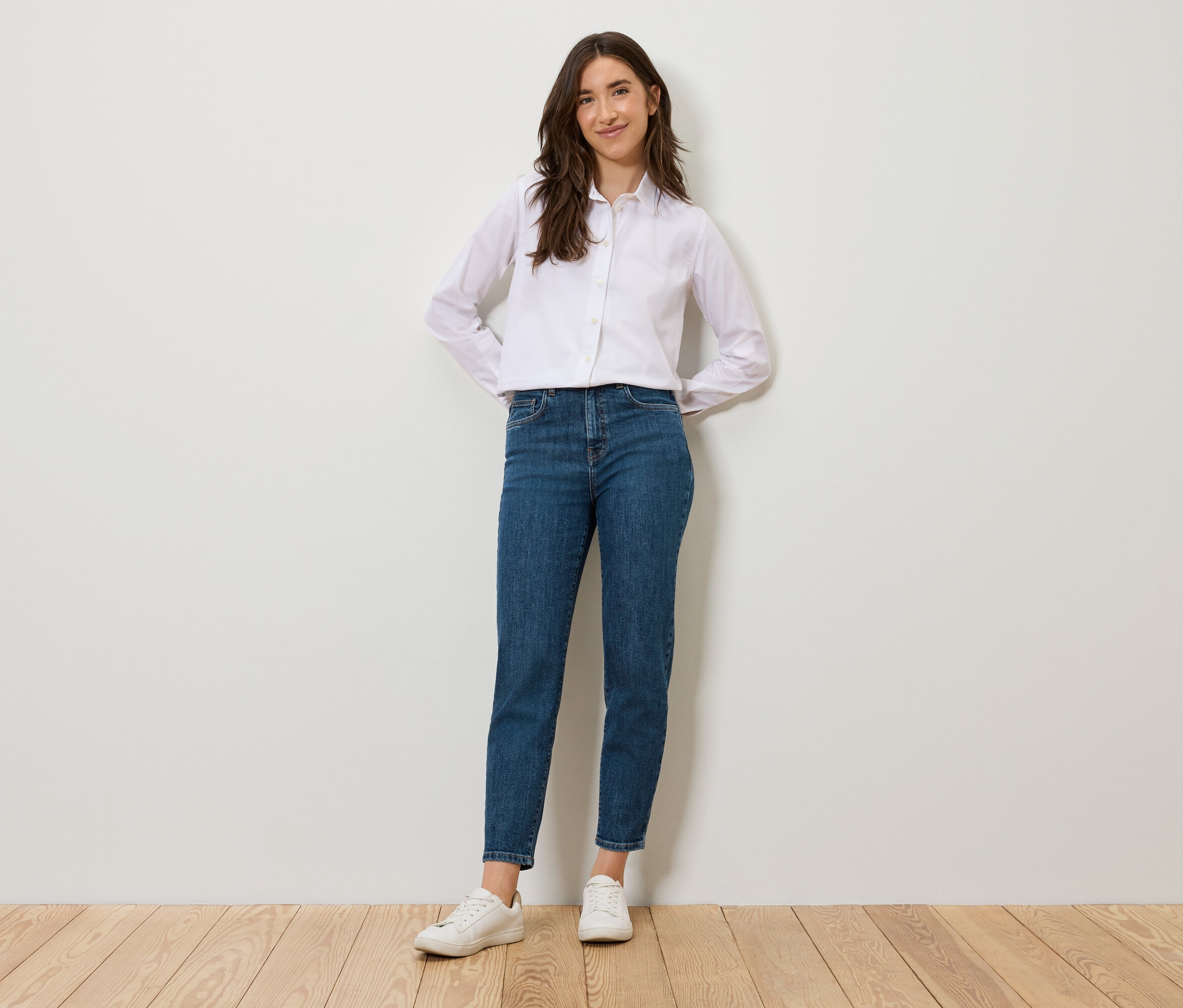 Frau steht und posiert in blauen Mom Jeans – Fit »Nyla«.