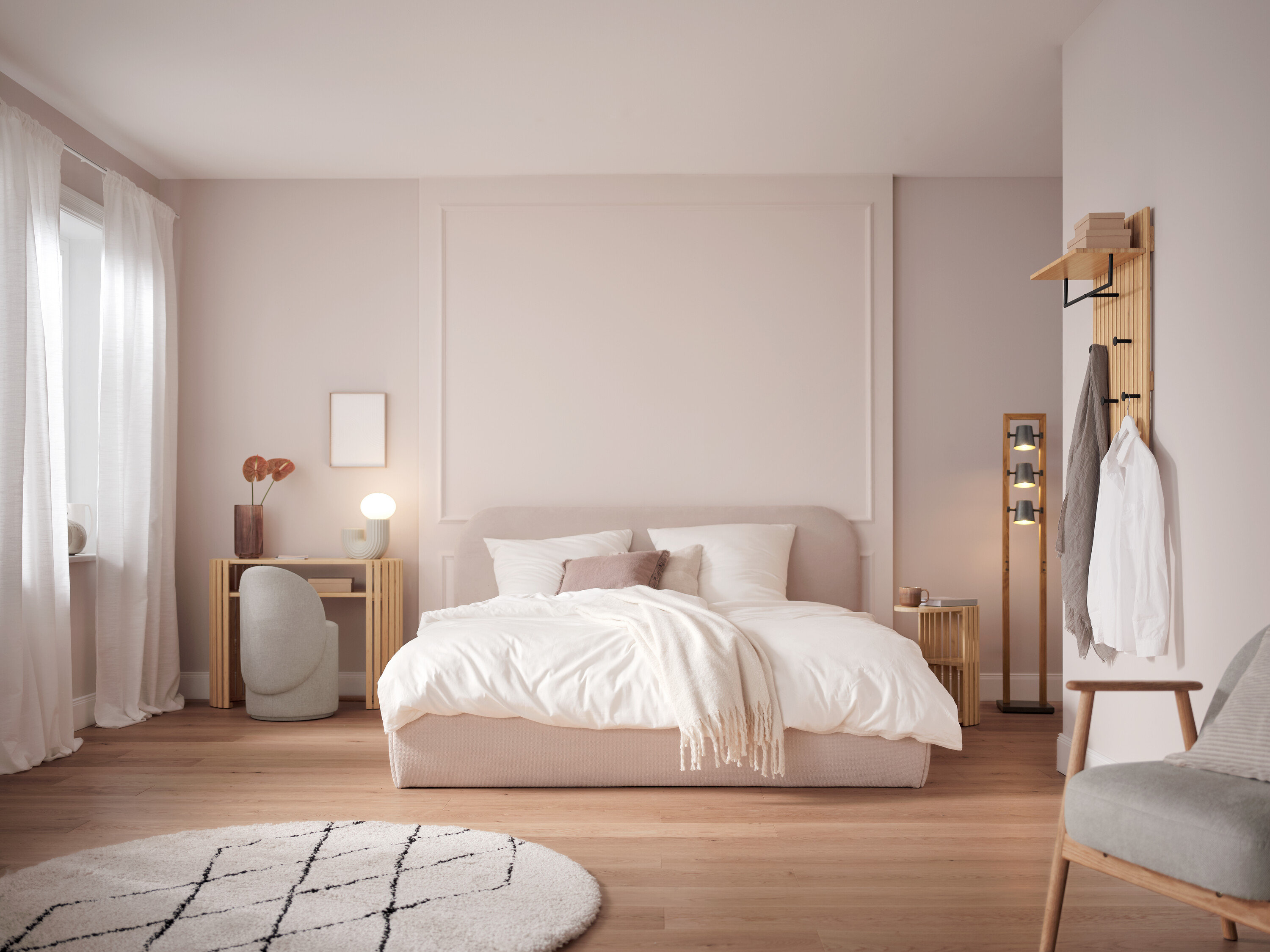 Schlafzimmer mit Bett mit weißer Bettwäsche, Tisch, Stuhl und Dekorationen.