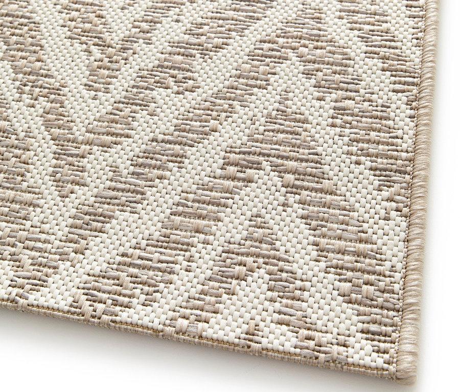 Detailaufnahme eines beigen Outdoor-Teppichs »Ecru Flow« mit geometrischem Muster.