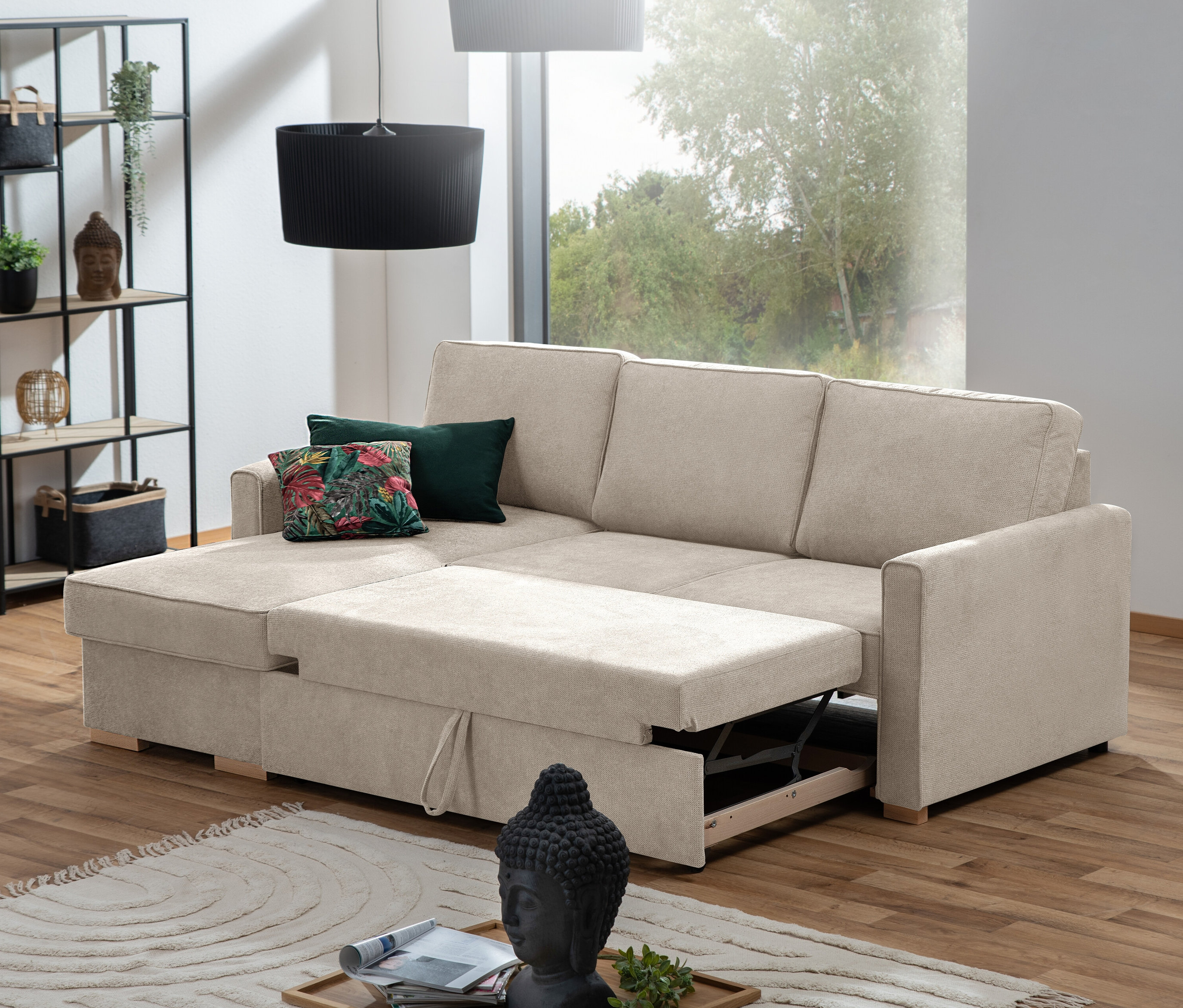 Beiges Ecksofa mit Auszugsbett »NovaLounge« teilweise ausgezogen vor Fenster. Auf der Couch liegen zwei Kissen.