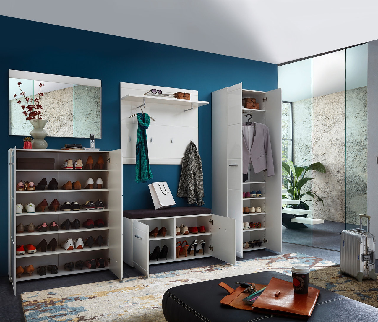 Flur mit weißem Garderobenschrank »ADANA«, Schuhregalen, Spiegel und Sitzbank vor blauer Wand.