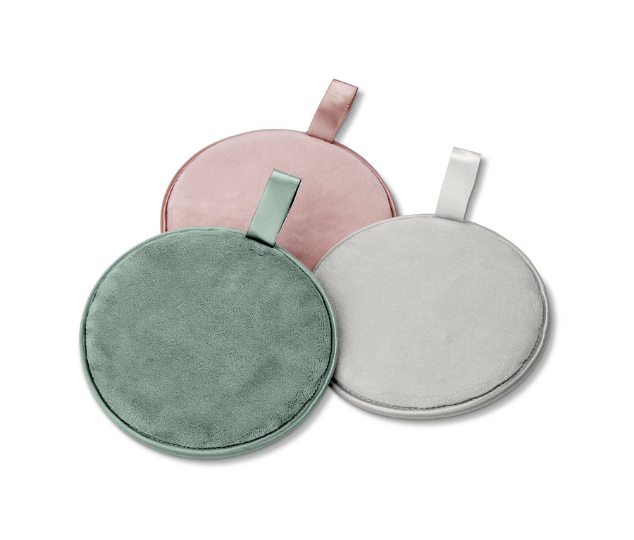 Drei extragroße Abschminkpads in Rosa, Grün und Grau liegen auf einem weißen Hintergrund.