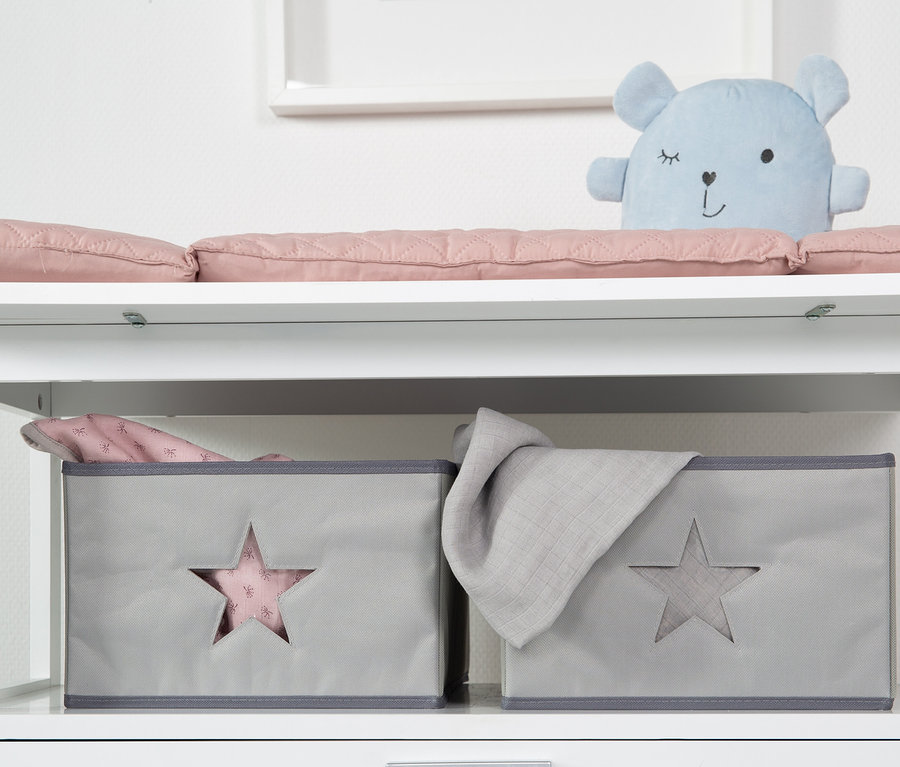 Weißer Wickeltisch mit rosa Auflage, blauem Teddybär und zwei grauen Aufbewahrungsboxen mit Sternen. Zu sehen ist die roba Wickelkommode »Hamburg« mit Wickelansatz.