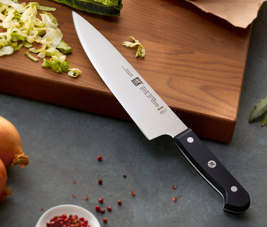 ZWILLING Gourmet-Messer-Set, 3-teilig liegt auf einem Schneidebrett mit geschnittenem Gemüse.