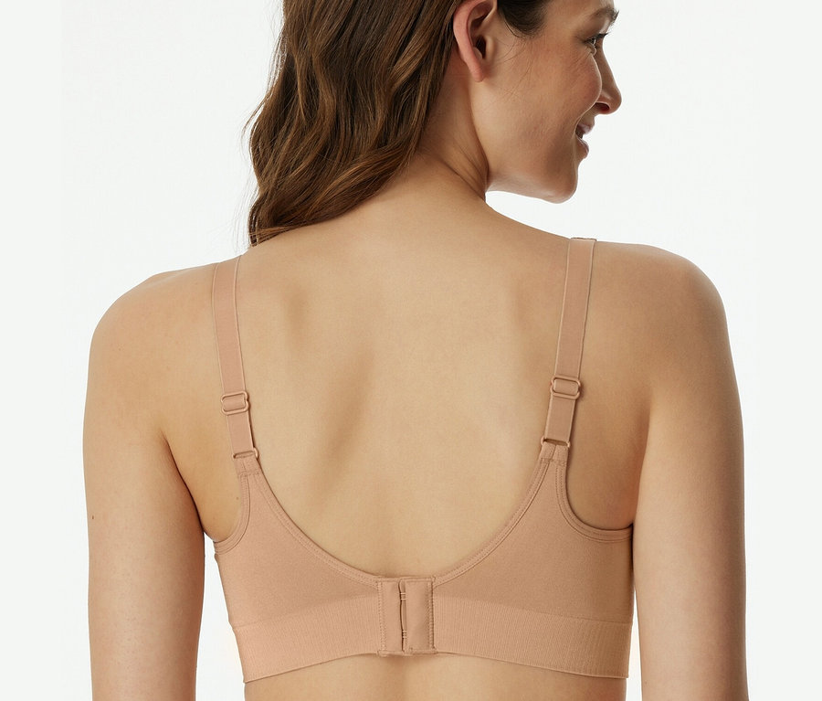 Rückansicht einer Frau mit braunen Haaren, die einen SCHIESSER Soft BH mit Pads in Maple trägt.