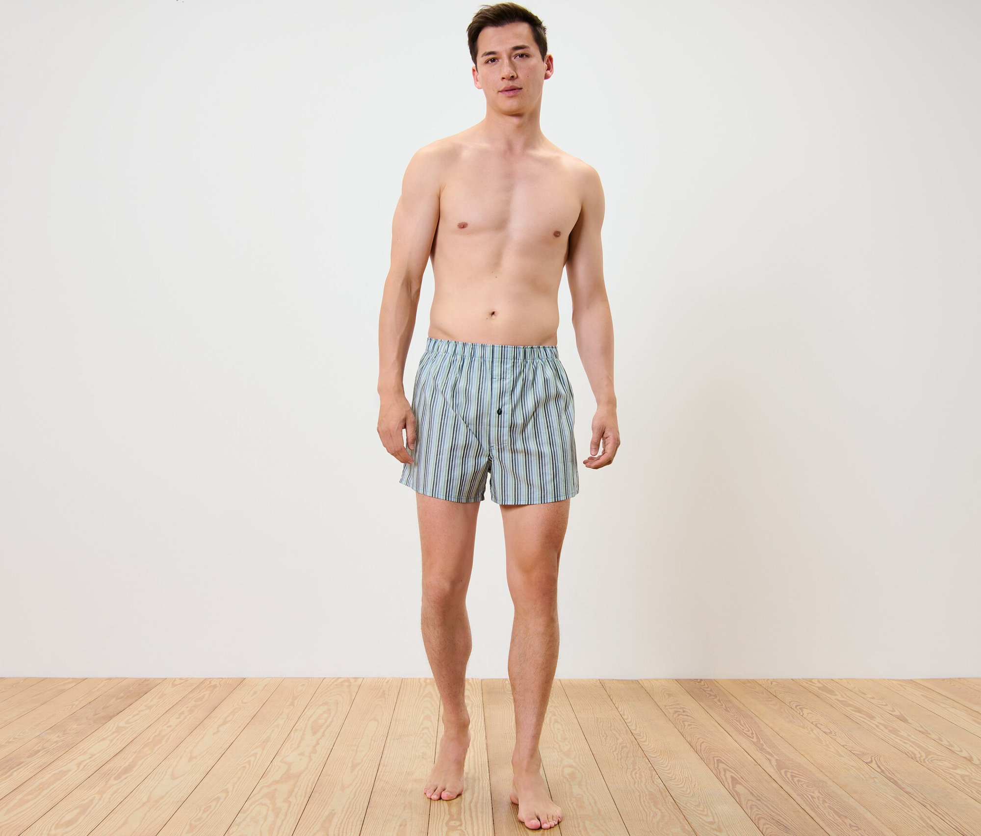 Mann steht und trägt 2 Web-Boxershorts.