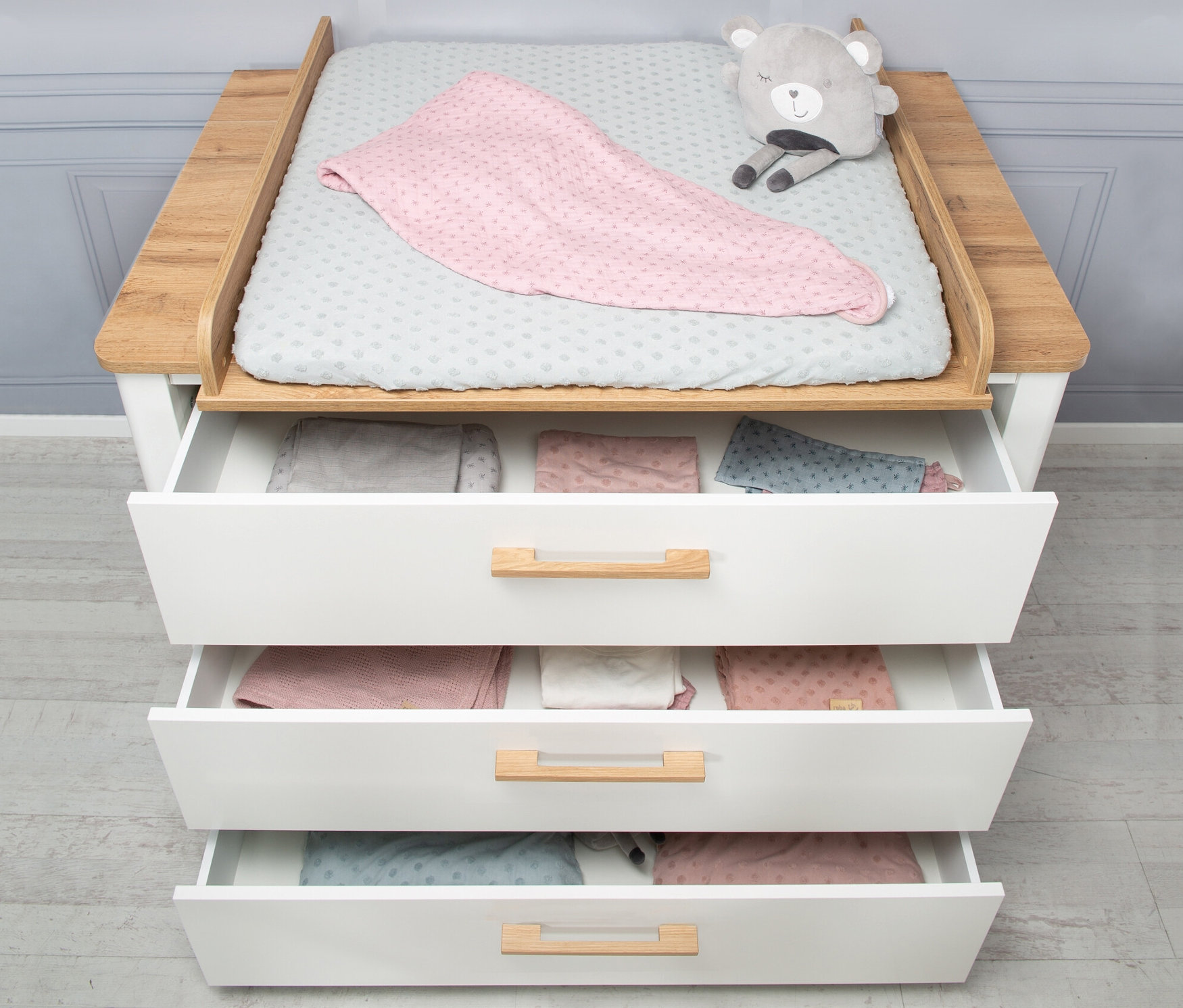 roba Kinderzimmer-Set »Ava« mit Bett und Wickelkommode, dessen offene Schubladen mit Kleidung gefüllt sind.