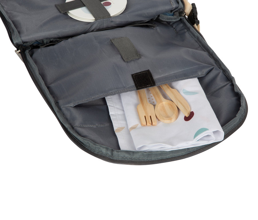 Offene Tasche mit Holzlöffel, Gabel und Messer auf einer bedruckten Serviette.