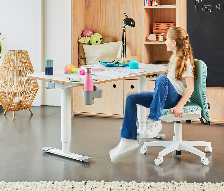 Mädchen sitzt auf einem mintfarbenen Topstar Sitness »Home S'cool« Stuhl an einem weißen Tisch.