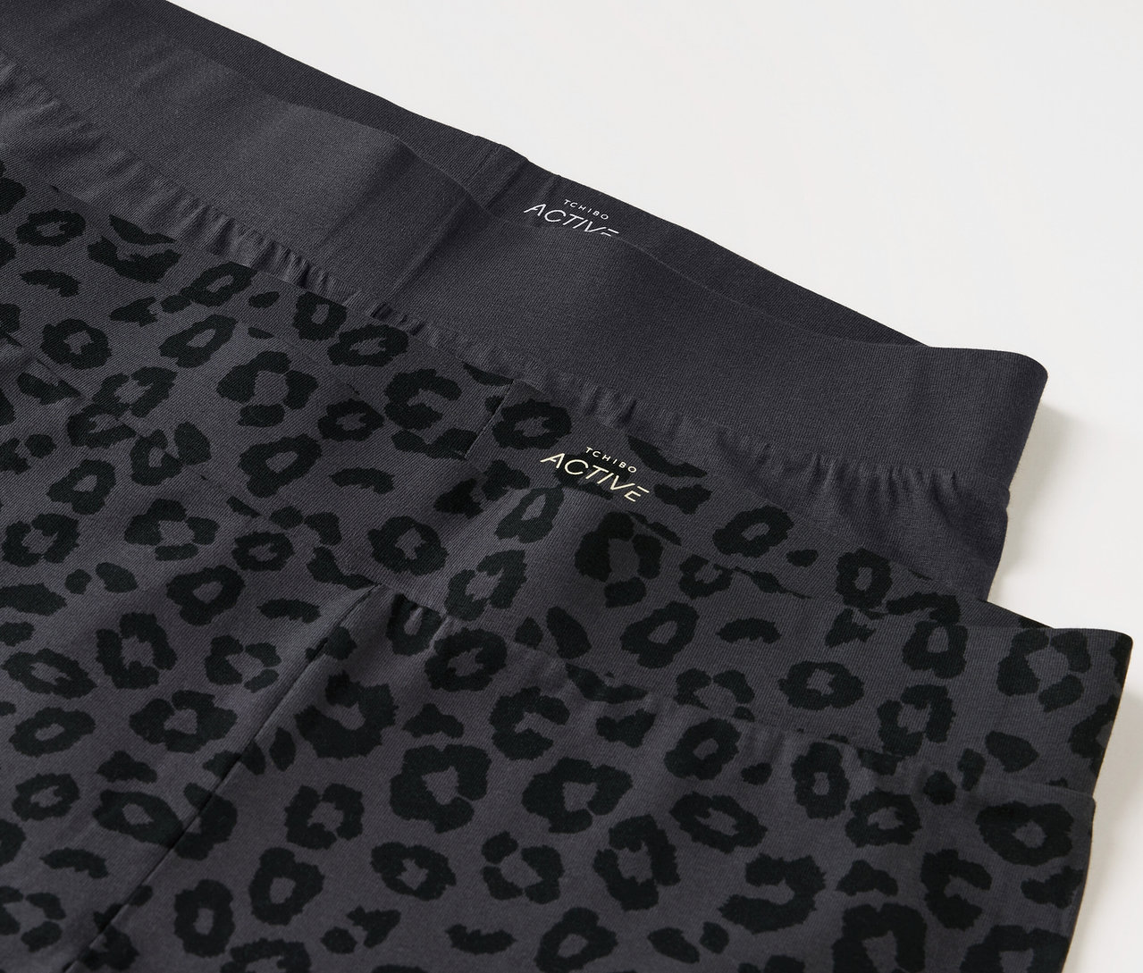 Zwei Leggings, eine schwarz und eine grau mit Tiermuster.