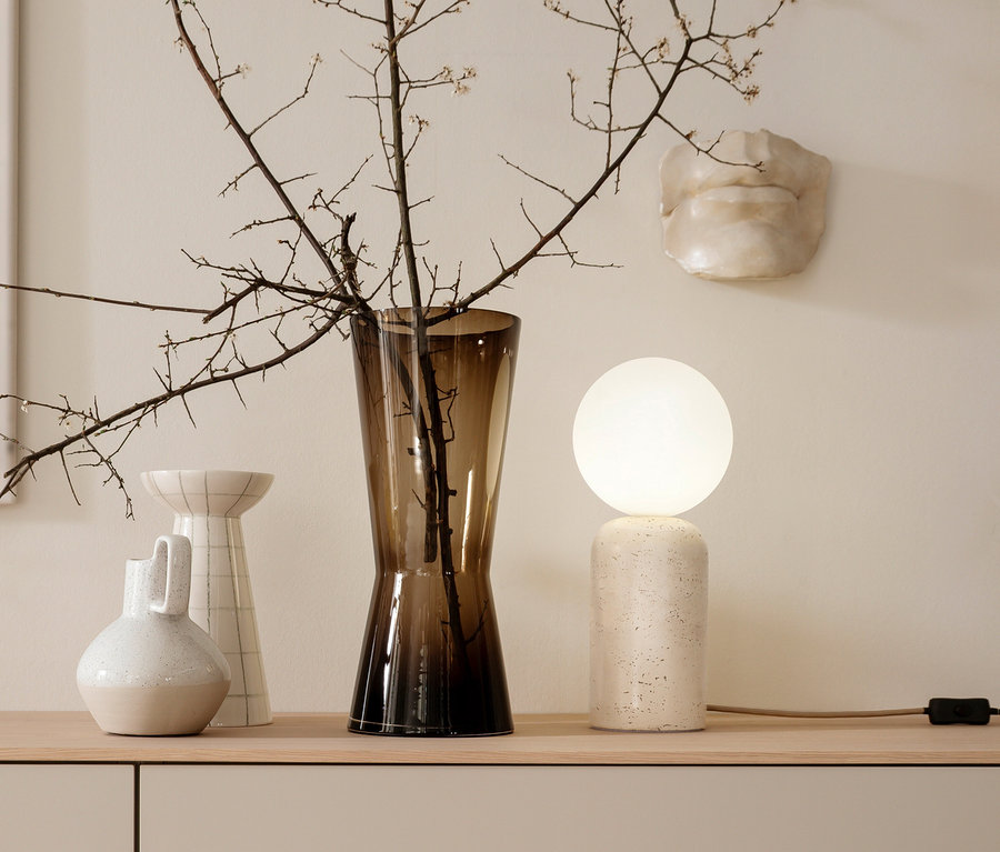 Dekorative Anordnung mit einer SCHÖNER WOHNEN-Kollektion Tischleuchte »Traventa«, Vasen und einem Zweig auf einem Sideboard.