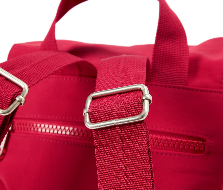 Nahaufnahme eines roten Rucksacks mit silbernen Schnallen an den Trägern.