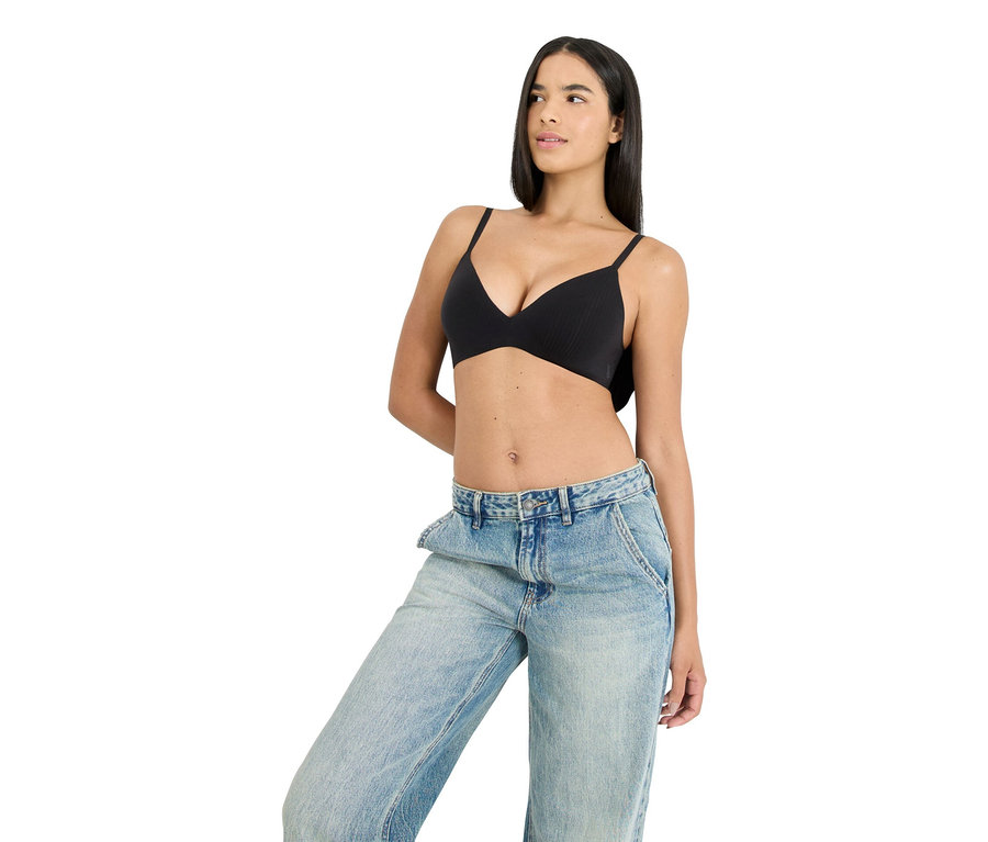 Frau trägt einen schwarzen BH und blaue Jeans.