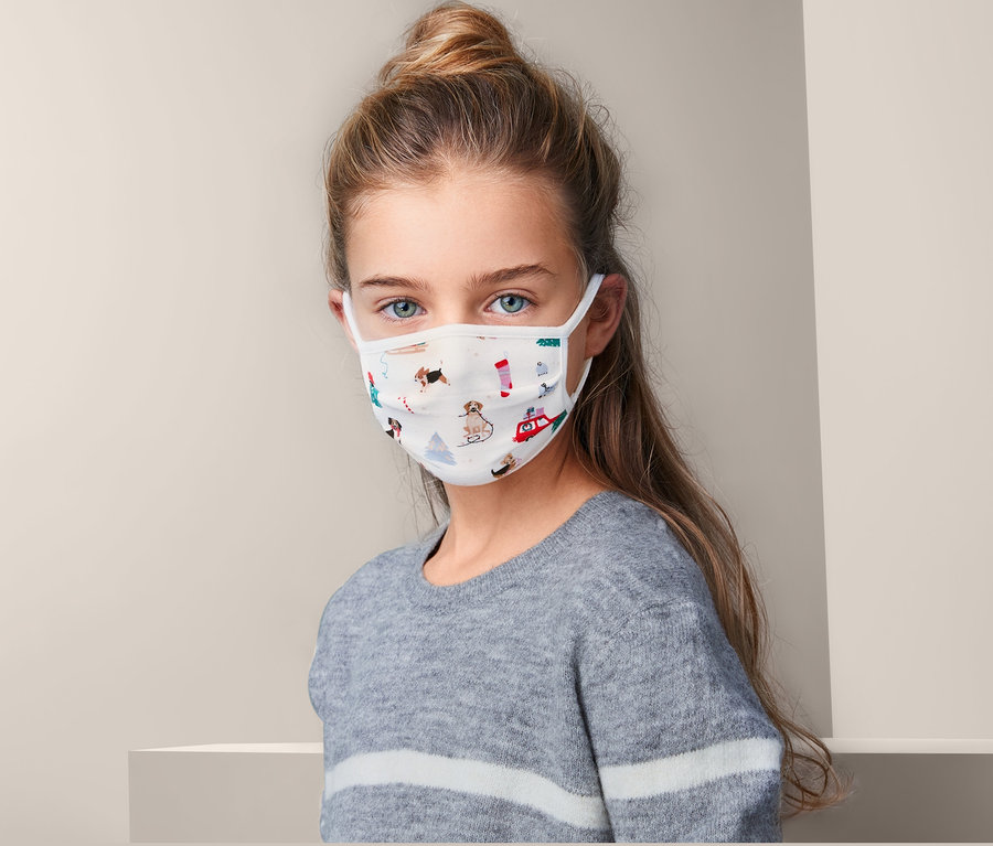 Porträt eines Mädchens, das ein Kids-Community-Masken-Set mit Muster trägt.