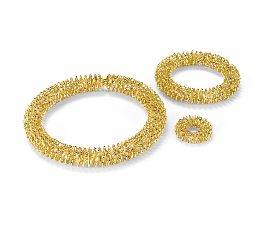 Goldfarbenes Akupressur-Set auf weißem Hintergrund.