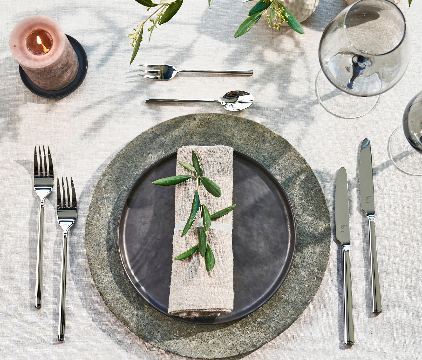 Gedeckter Tisch mit Tellern, Gläsern, Kerzen und ZWILLING Besteck, poliert, 60-teilig.