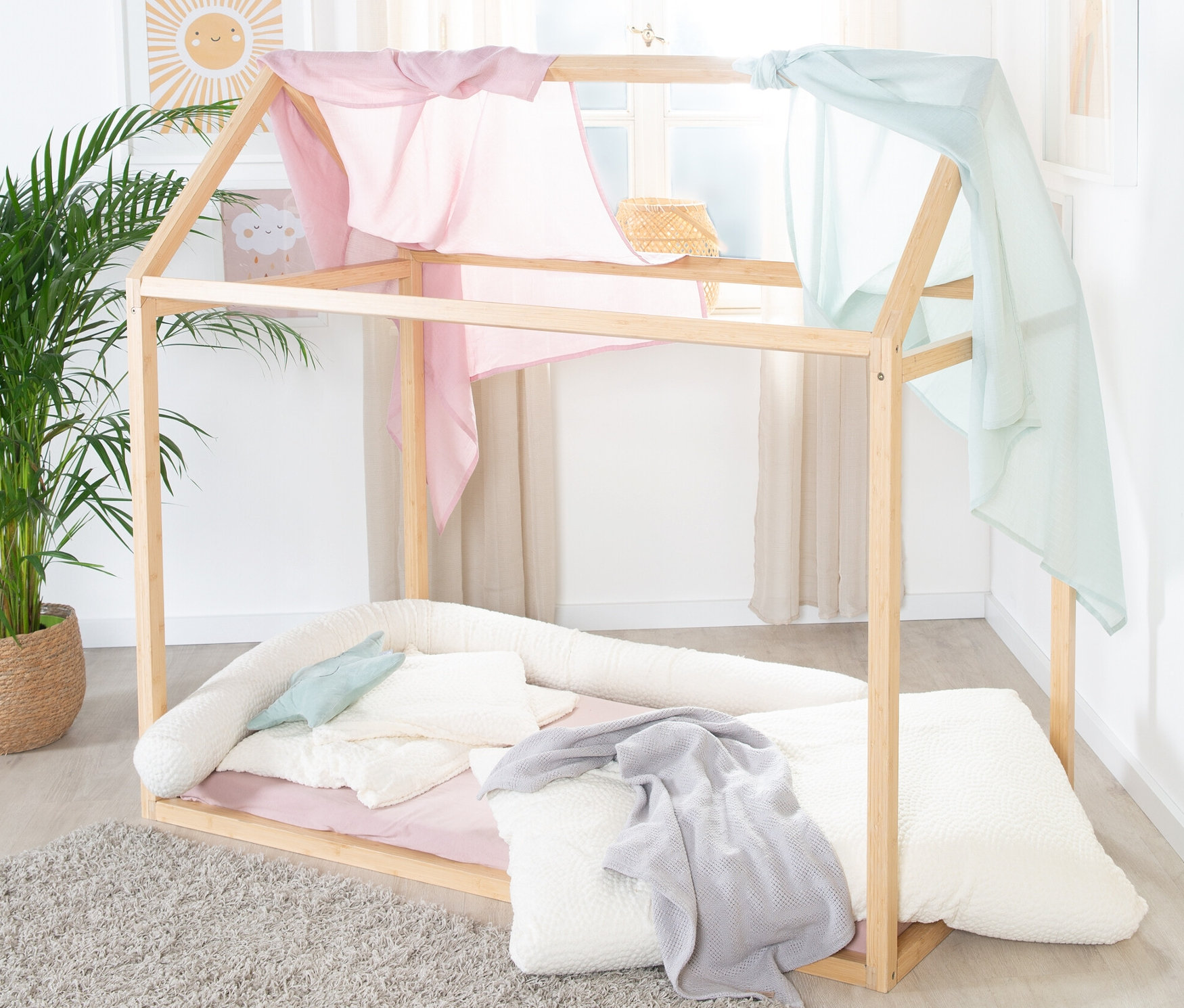 Ein roba Hausbett, ca. 70 x 140 cm, aus Bambus, mit rosa und blauem Stoff oben.