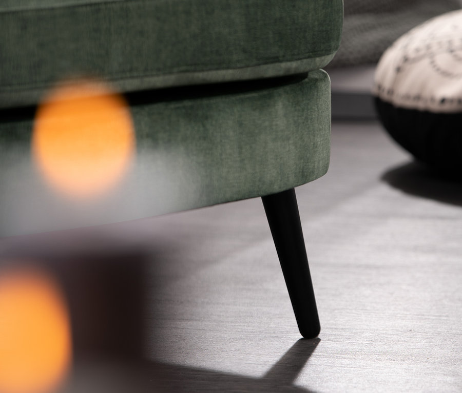 Detailansicht von Sessel »Miranda«, dunkelgrün, mit schwarzen Beinen auf grauem Untergrund.