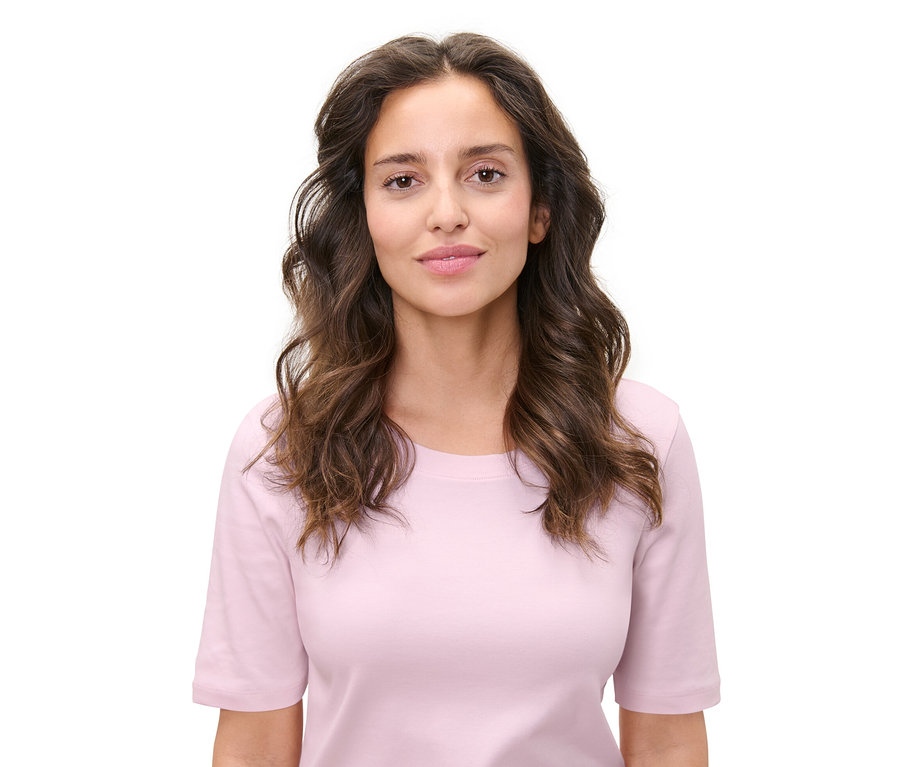 Porträt einer Frau mit gewelltem Haar. Hitzefreie Lockenwickler wurden offenbar verwendet, um diese Frisur zu kreieren.