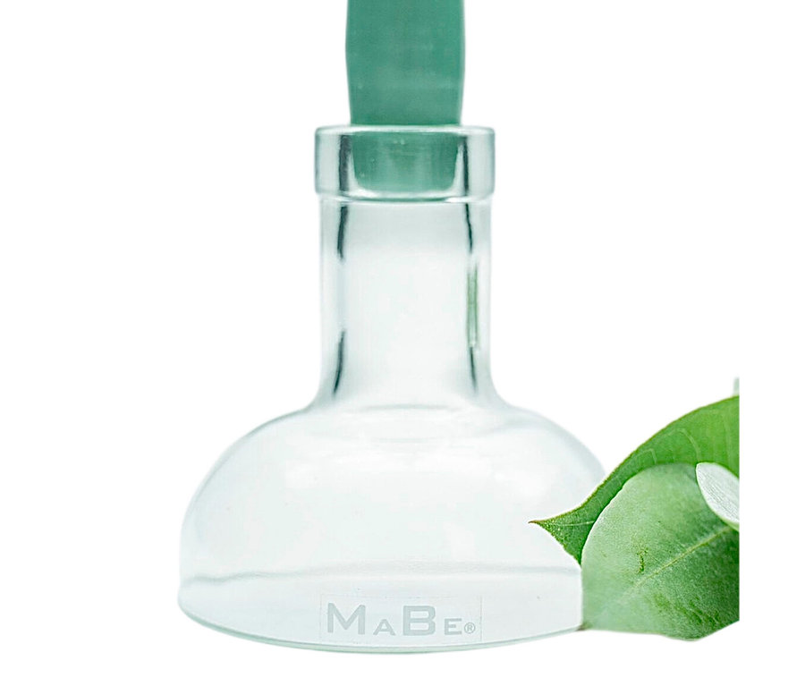 Klarer Glas-Kerzenhalter mit grüner Kerze und Blatt.