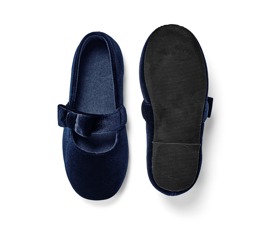 Marineblaue Kinder-Samt-Ballerinas, von denen einer mit der Sohle nach oben liegt.