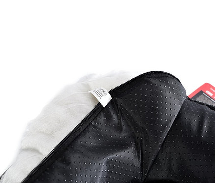 Detailansicht vom Inneren eines schwarzen Outdoor-Hundebetts mit Reißverschluss und weißem Plüscheinsatz.