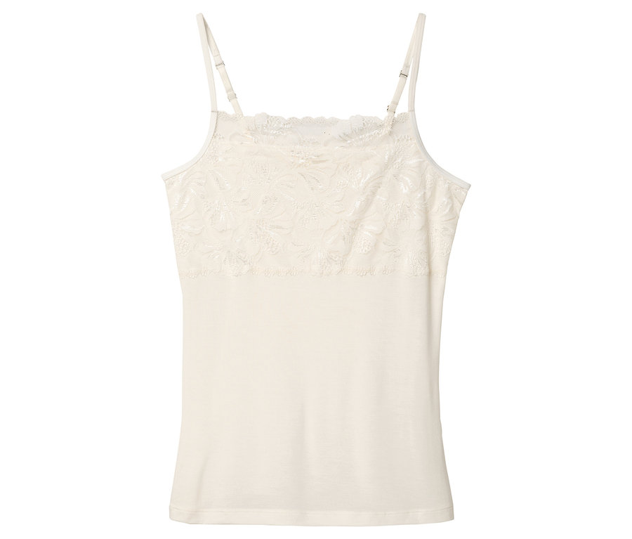 Ein einzelnes, creme farbenes Hemdchen mit Spitze liegt auf einem weißen Hintergrund.