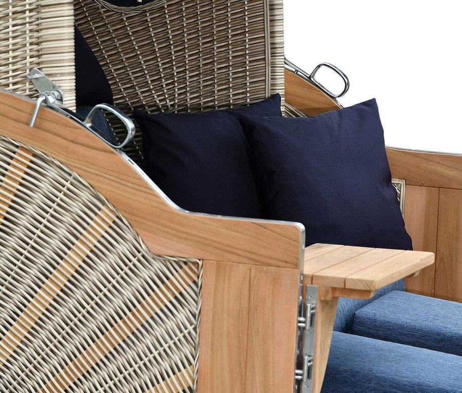 Detailansicht eines Strandkorbs mit blauem Stoffdach und zwei blauen Kissen.