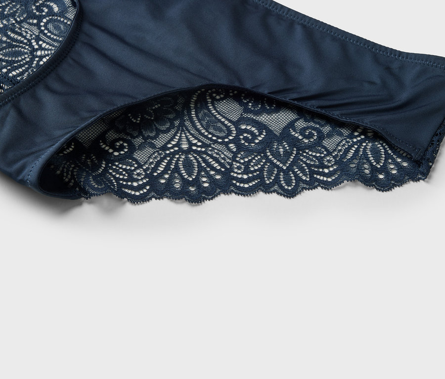 Nahaufnahme eines marineblauen Damenhöschens mit Spitzenbesatz.