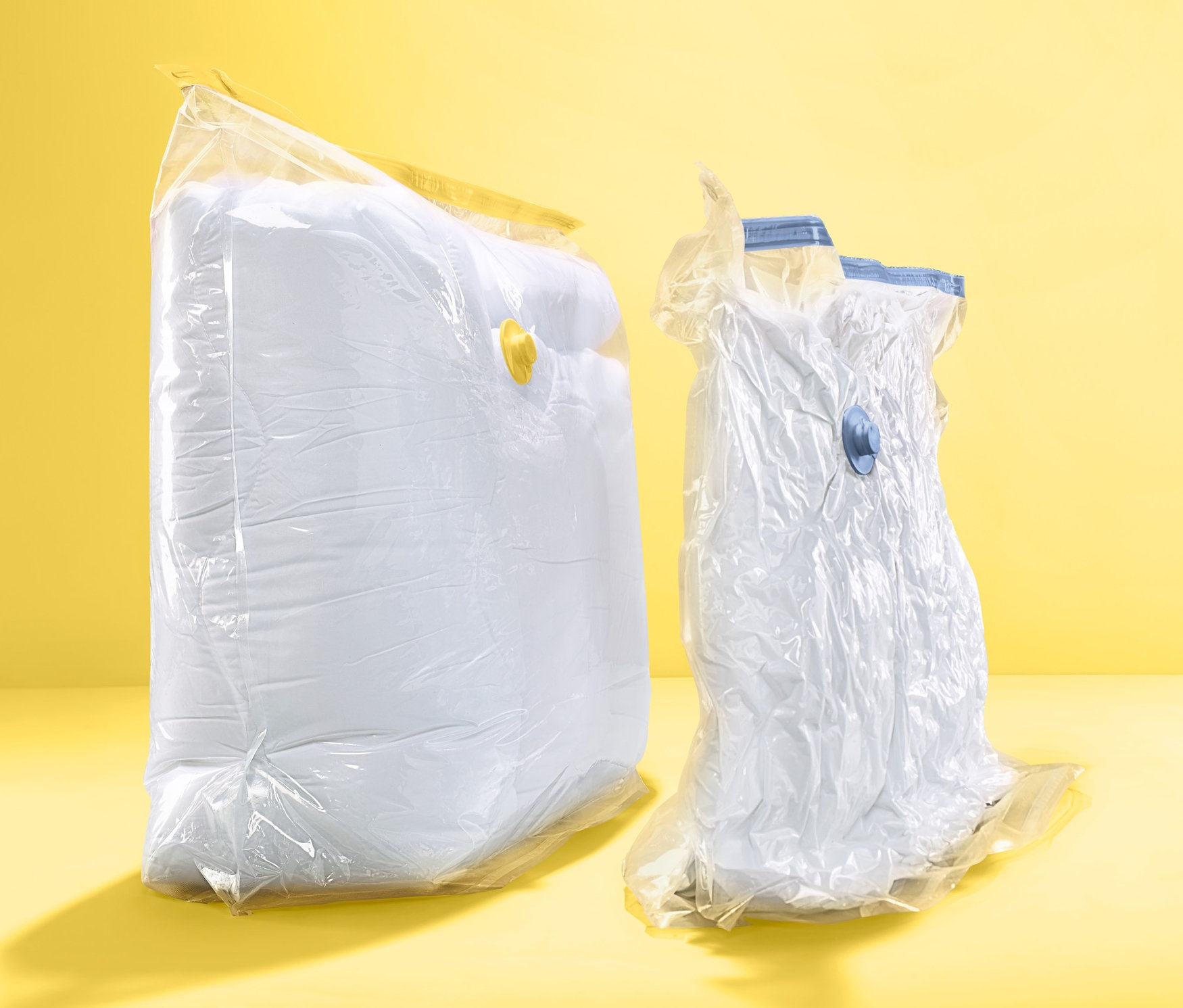 Zwei Vakuum-Aufbewahrungsbeutel, Würfel, auf gelbem Hintergrund.