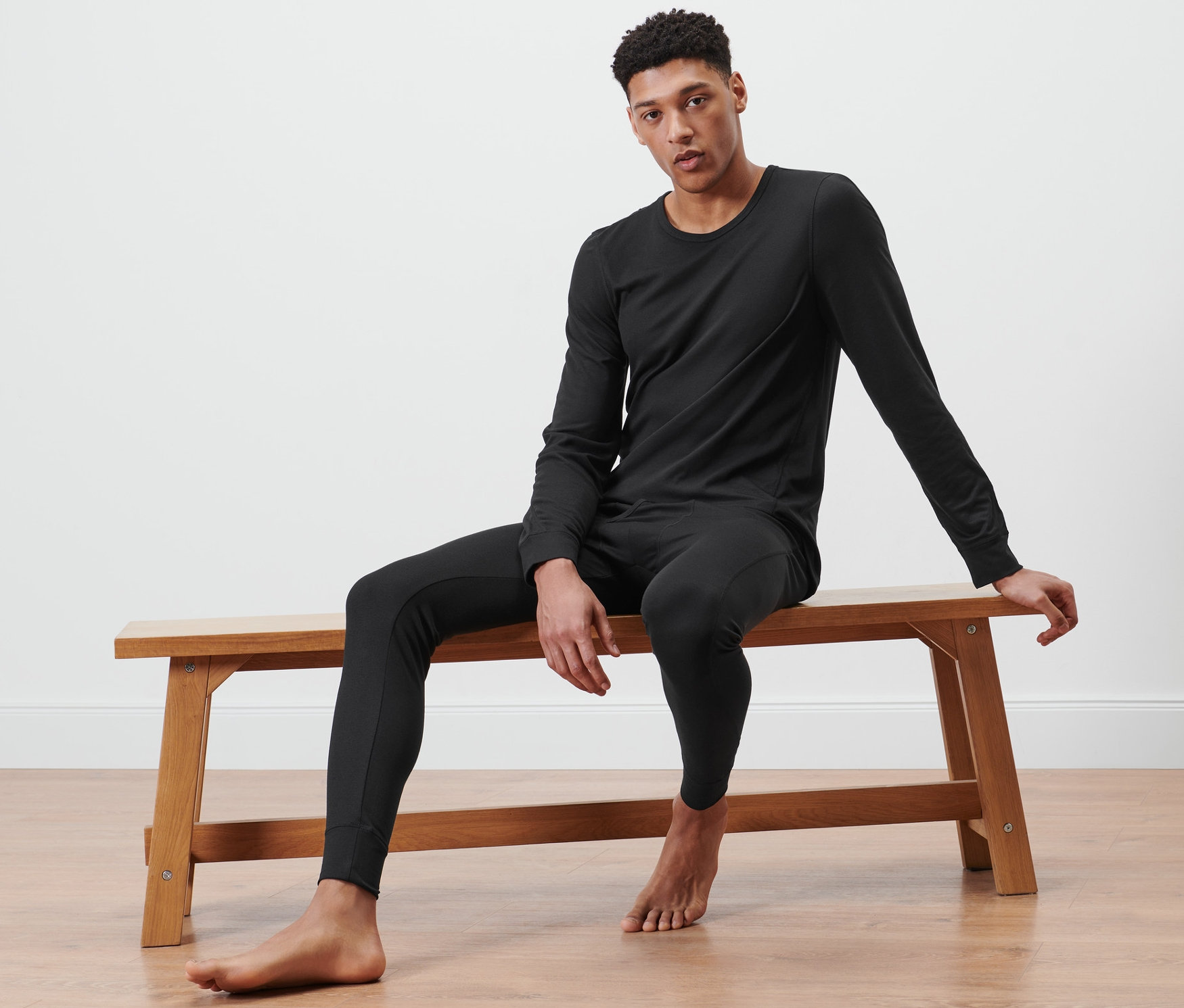 Mann sitzt auf Bank und trägt Thermo-Funktionsunterwäsche.