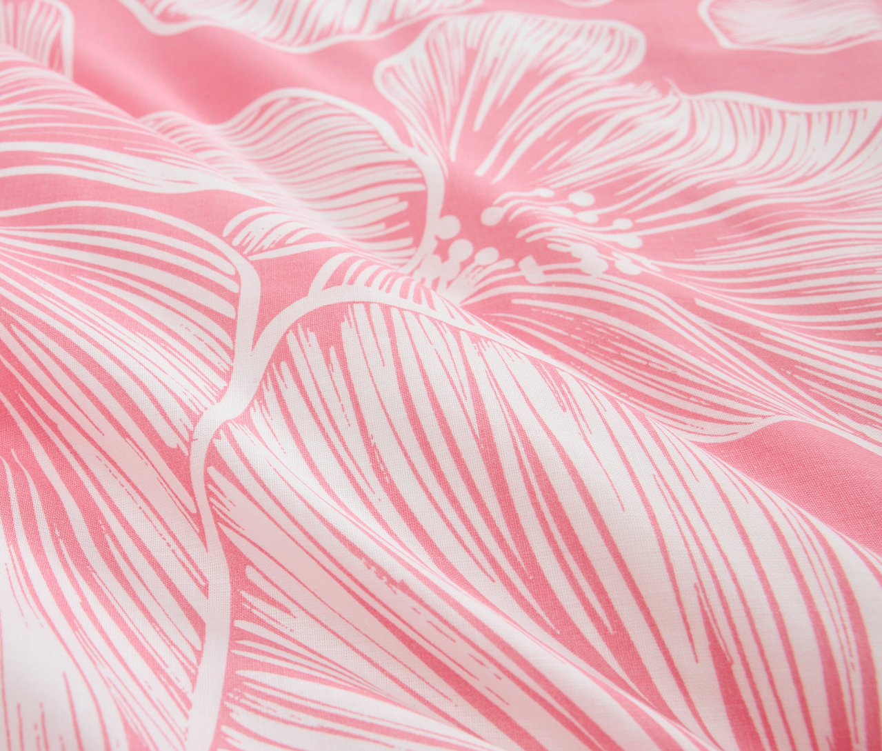 Detailaufnahme eines rosafarbenen Stoffes mit weißem Blumenmuster.