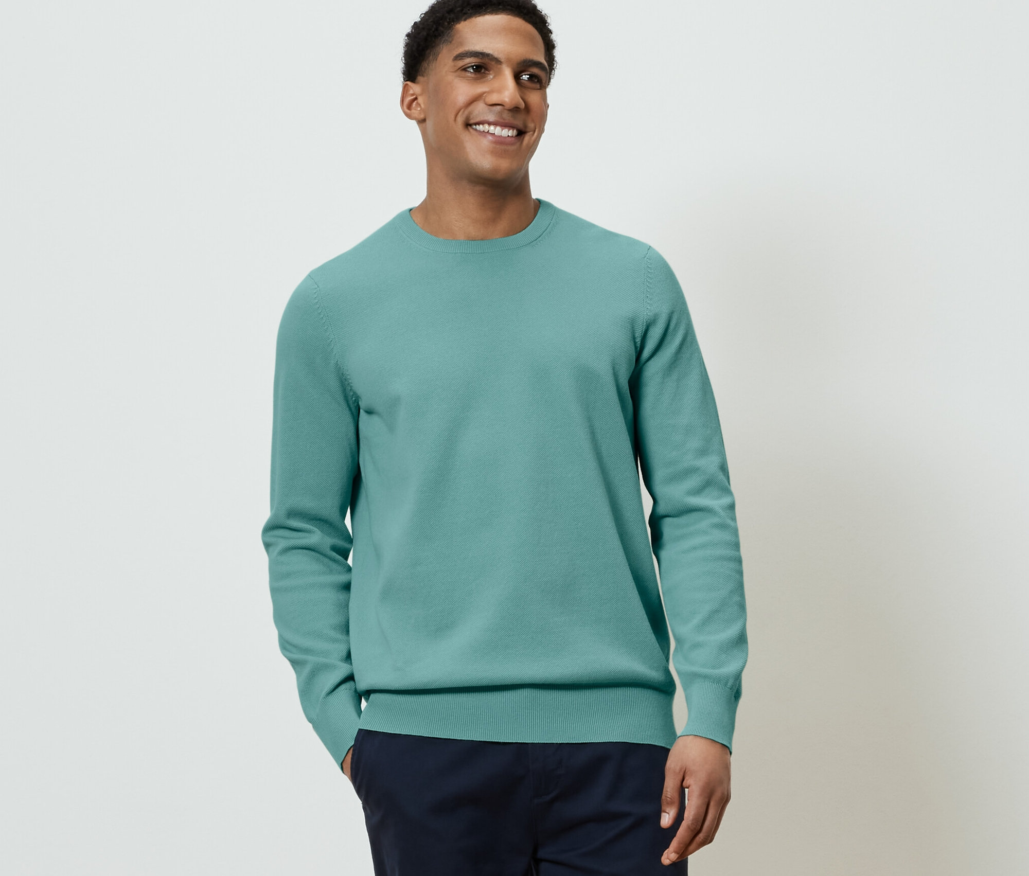 Mann trägt Strick-Pullover.