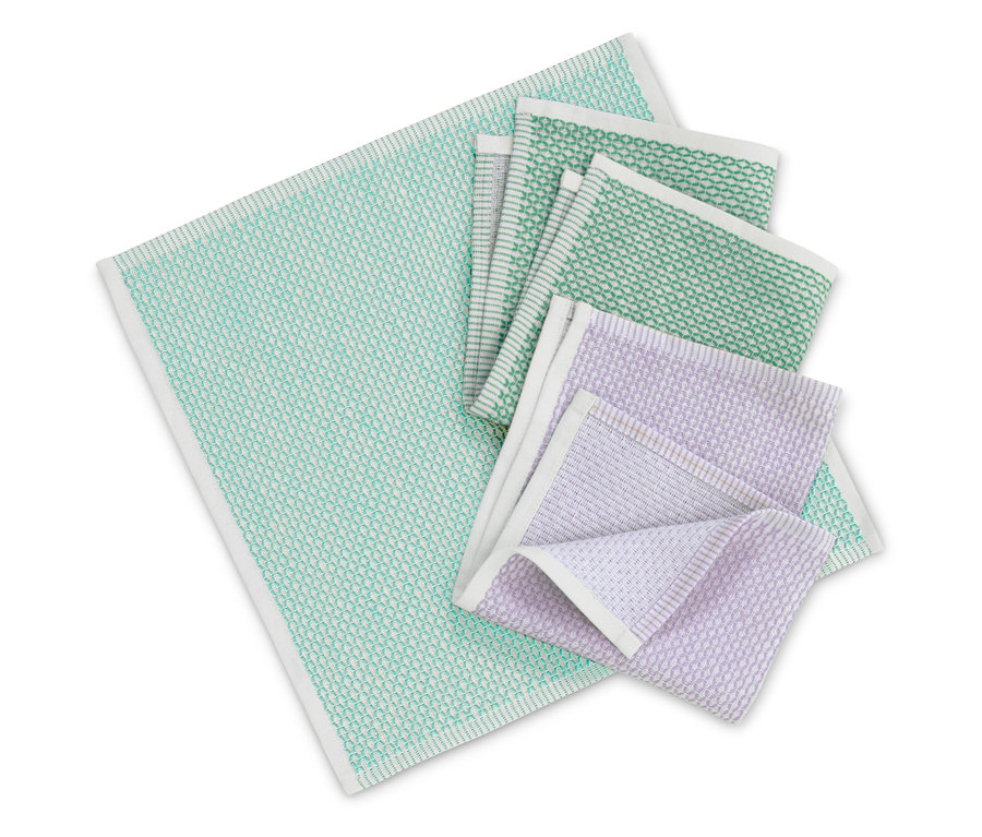 Verschiedenfarbige Stoffservietten mit weißem Rand auf weißem Hintergrund gefaltet.